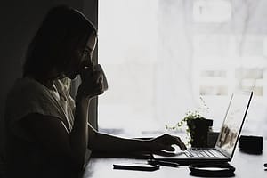 Woman drinking coffee on laptop